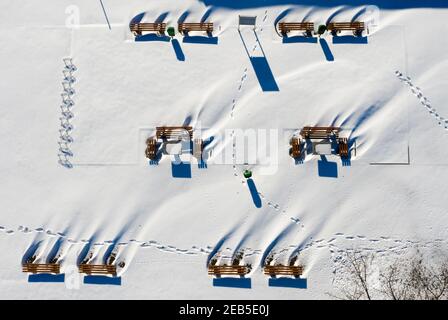 11. Februar 2021, Sachsen-Anhalt, Wörlitz: Tische und Bänke werfen lange Schatten auf einem eingeschneiten Rastplatz. (Luftaufnahme mit Drohne) Foto: Jan Woitas/dpa-Zentralbild/dpa Stockfoto