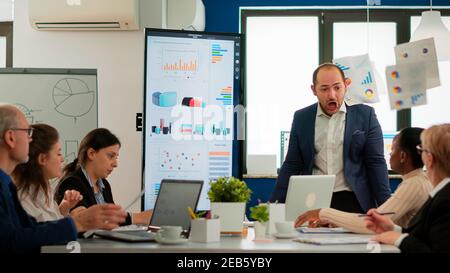 Nervöser Geschäftsmann streitend in Coworking mit Konflikt am Arbeitsplatz beschuldigt schlechte Arbeit Inkompetenz Fehler. Rügen erfolglose Ergebnisse und Rivalität Konzept. Stockfoto