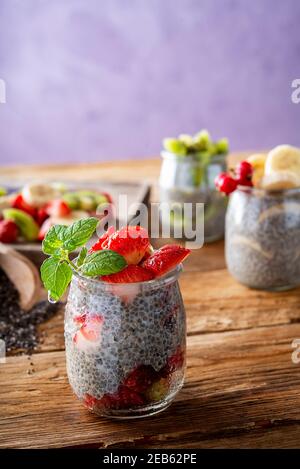 Vegane Erdbeere Chia Pudding in Glas Holzbrett Stockfoto