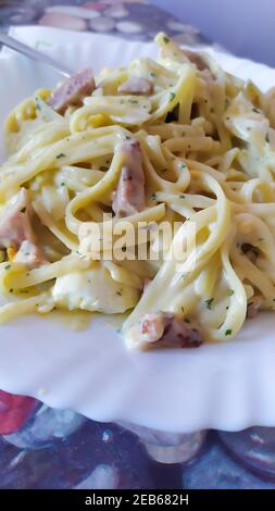 Nahaufnahme vertikale Aufnahme einer appetitlichen hausgemachten Pasta Carbonara mit Geräuchertes Schweinefleisch auf einem pla serviert Stockfoto