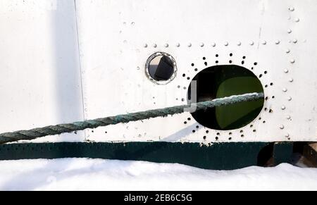 Alte Schiffsseite mit Loch und Hawser, nautischer Hintergrund. Stockfoto
