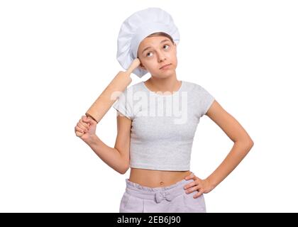 Mädchen in einem Koch Hut mit Emotionen halten ein Nudelholz isoliert auf einem weißen Hintergrund. Stockfoto