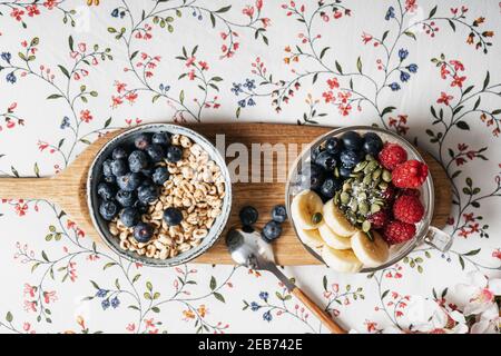 Frühstückstablett im Bett mit Müsli, Joghurt und Obst Stockfoto