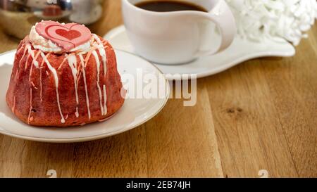 Himbeer- und Erdbeerzucker glasierte Torte zum Frühstück mit Herzdeko in einem Café. Nahaufnahme, Makro. Stockfoto