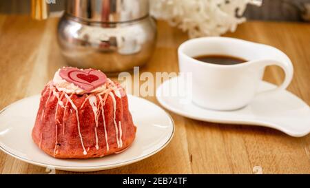 Himbeer- und Erdbeerzucker glasierte Torte zum Frühstück mit Herzdeko in einem Café. Nahaufnahme, Makro. Stockfoto