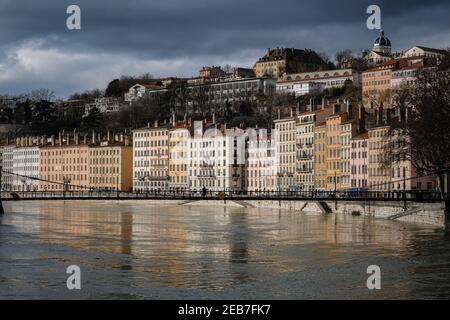 Lyon (Frankreich), Februar 10 2021. Licht an den Fassaden der Gebäude entlang des Quai Saint Vincent mit der Fußgängerbrücke über die Saône. Stockfoto