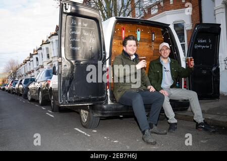 George Dean (L), ein ehemaliger Bar-Manager und Finn Bruce (R), ein Video-Regisseur mit ihrem "Pub-on-wheels" in Clapham, Süd-London. George und Finn fahren zu den Türen der Leute, um ihnen Pints zu schenken und schaffen mehr ein Pub-Erlebnis als Dosen in ihren Wohnzimmern. Bilddatum: Freitag, 12. Februar 2021. Stockfoto