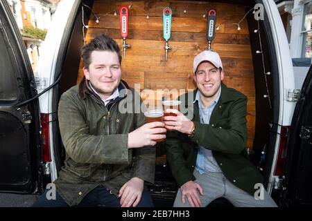 George Dean (L), ein ehemaliger Bar-Manager und Finn Bruce (R), ein Video-Regisseur mit ihrem "Pub-on-wheels" in Clapham, Süd-London. George und Finn fahren zu den Türen der Leute, um ihnen Pints zu schenken und schaffen mehr ein Pub-Erlebnis als Dosen in ihren Wohnzimmern. Bilddatum: Freitag, 12. Februar 2021. Stockfoto