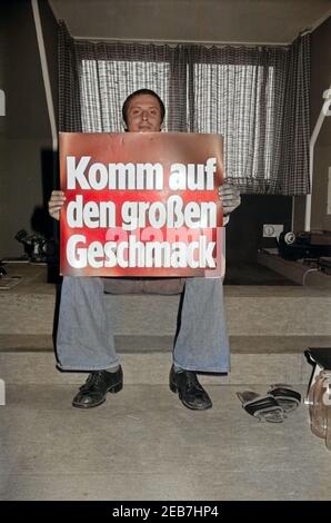 Der Deutsche Liedermacher Konstantin Wecker Mit Werbeplakat "Komm Auf Den Großen Geschmack", 1970er Jahre Deutschland. Deutsche Liedermacher Konstantin Wecker mit einem Display Werbung, Deutschland der 1970er Jahre. 24x36Neg696 Stockfoto