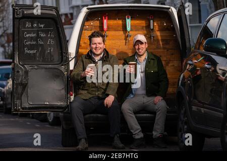 George Dean (L), ein ehemaliger Bar-Manager und Finn Bruce (R), ein Video-Regisseur mit ihrem "Pub-on-wheels" in Clapham, Süd-London. George und Finn fahren zu den Türen der Leute, um ihnen Pints zu schenken und schaffen mehr ein Pub-Erlebnis als Dosen in ihren Wohnzimmern. Bilddatum: Freitag, 12. Februar 2021. Stockfoto