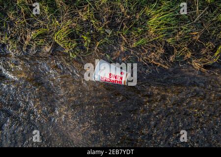 Leere Burger King Coca Cola Getränke Tasse schwimmend eine überflutete Straße. Stockfoto