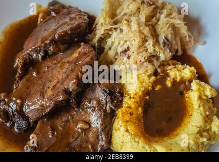 Schweineribs mit Polenta und Sauerkraut. Typisches Trentiner Gericht - italienische Küche Stockfoto