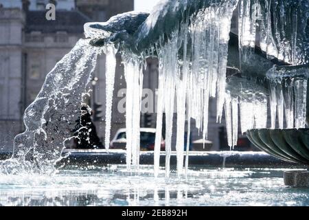 Eiszapfen hängen an einem gefrorenen Brunnen auf dem Trafalgar Square in London, während der Kälteeinbruch weiterhin einen Großteil der Nation in ihren Bangen hält. Bilddatum: Freitag, 12. Februar 2021. Stockfoto