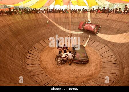 (210212) -- BOGURA, 12. Februar 2021 (Xinhua) -- EIN Stuntman führt seine Fähigkeiten auf seinem Fahrzeug an der Holzwand während einer Messe in Bogra, Bangladesch, 10. Februar 2021. (Xinhua) Stockfoto