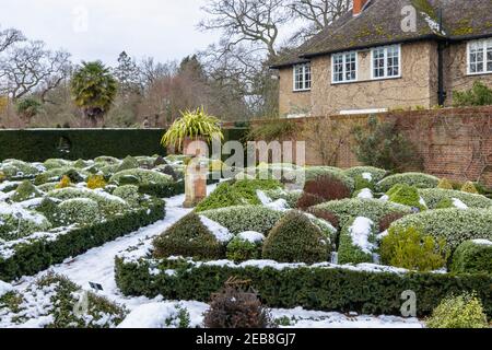 Der formelle Knot Garden im RHS Garden, Wisley, Surrey, Südostengland, im Winter mit ordentlich beschnittenen Büschen und Hecken, die mit Schnee bedeckt sind Stockfoto