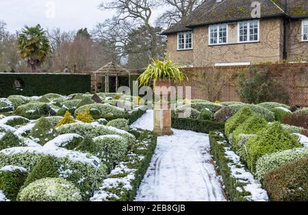 Der formelle Knot Garden im RHS Garden, Wisley, Surrey, Südostengland, im Winter mit ordentlich beschnittenen Büschen und Hecken, die mit Schnee bedeckt sind Stockfoto