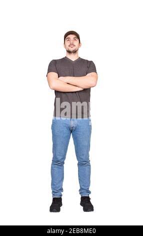Volle Länge selbstbewussten Mann Mitarbeiter, hält die Arme gekreuzt, Blick nach vorne isoliert auf weißem Hintergrund. Positive männliche Mütze und lässige Kleidung Stockfoto