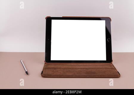 Ein Tablet mit weißem Bildschirm auf dem Bürotisch und Ein Stift in der Nähe Stockfoto