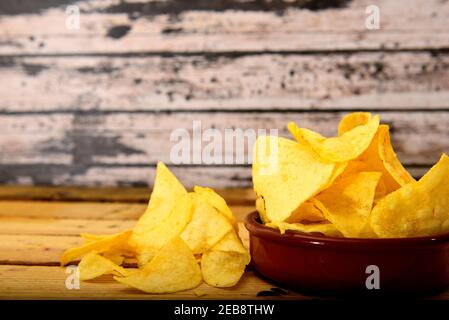 Hausgemachte Chips in einem Keramiktopf auf einem Holztisch Stockfoto