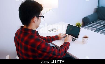 Junge asiatische Mann entspannen auf dem Stuhl zufrieden mit seiner Arbeit. Hochwertige Fotos Stockfoto