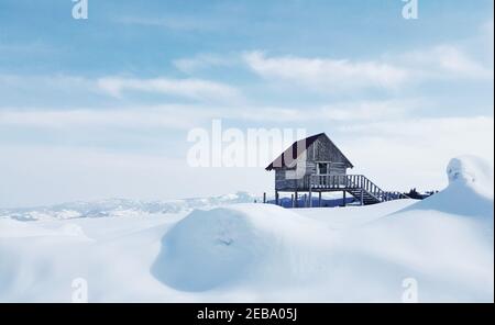 Kleines Holzhaus auf einem schneebedeckten Feld, das in Kulakkaya Plateau, Giresun, Türkei gefangen wurde Stockfoto