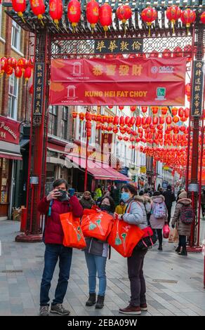 London UK 12 February 2021 EINE sehr ruhige Gerrad Street in London Chinatown, mit Pandemie drohende keine Feiern erlaubt wurden in diesem Jahr, Menschen Schlange vor Restaurants und nahm Selfies vor den chinesischen Toren, auch Dansey Place, wo die Behälter gelagert wurden hatte einige Dekorationen.Paul Quezada-Neiman/Alamy Live News Stockfoto