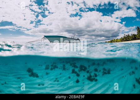 Tropischer transparenter Ozean mit weißem Boot in Mauritius. Geteilte Ansicht. Stockfoto