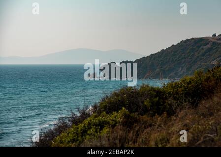 Küstenklippen und Meerblick. Eine Insel im Nebel am Horizont. Stockfoto