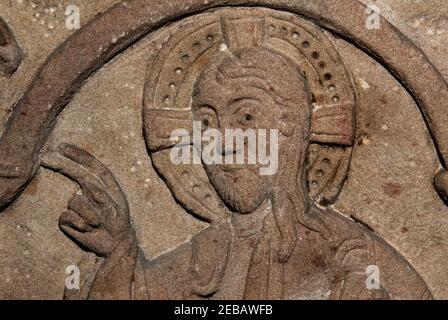 Christus segnet Adeloch (786-823 n. Chr.), Bischof von Straßburg. Elsässische romanische Skulptur, die im 12.. Jahrhundert, lange nach Adelochs Tod, auf dem Sarkophag des Bischofs geschaffen wurde. Dieser Sarkophag befindet sich jetzt in der Kirche, die Adeloch gegründet hat, der Église Saint-Thomas, in Straßburg, Frankreich. Stockfoto