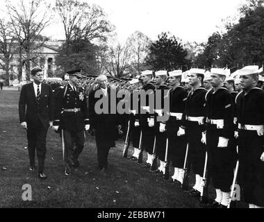 Ankunftszeremonie für Konrad Adenauer, Bundeskanzler der Bundesrepublik Deutschland, 10:45am Uhr. Präsident John F. Kennedy und Bundeskanzler der Bundesrepublik Deutschland, Dr. Konrad Adenauer, überprüfen Ehrengarde-Truppen während der Ankunftszeremonien zu Ehren von Bundeskanzler Adenauer. Truppenkommandant, Oberst John W. Gorn, geht mit Präsident Kennedy und Bundeskanzler Adenauer spazieren; der Dolmetscher für das deutsche Außenministerium, Heinz Weber, geht hinterher. South Lawn, White House, Washington, D.C. Stockfoto