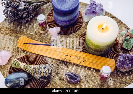 Kleine gute feng Shui Altar in zu Hause auf Fensterbank auf Blatt Form Tischmatte, verschneite nordische Natur auf Hintergrund. Räucherkerze rauchen, Edelsteine für de Stockfoto