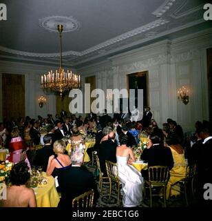 Abendessen zu Ehren von Herrn u0026 Frau Stephen E. Smith, 8:00pm Uhr. Die Gäste besuchen ein Abendessen zu Ehren von Stephen E. Smith und Jean Kennedy Smith. Präsident John F. Kennedy steht in der Mitte (zurück zur Kamera). State Dining Room, White House, Washington, D.C. Stockfoto