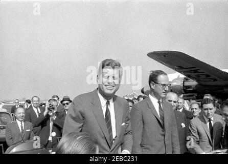 Wahlkampfreise des Kongresses: New York City, Ankunft. Präsident John F. Kennedy steht in der Präsidentenlimousine bei der Ankunft am LaGuardia Airport in New York City, New York, während einer Wahlkampfreise im Kongress. Kandidat für Gouverneur von New York, Robert Morgenthau, steht im Auto auf der rechten Seite; Kandidat für Surrogate of Queens County, John T. u201cPatu201d Clancy (teilweise versteckt auf der rechten Seite), bereitet sich auf den Schritt in Auto. Ebenfalls im Bild: Wochenschau-Fotograf für United Press Movietone, Thomas J. Craven, Sr.; White House Secret Service Agent, Bill Greer. Stockfoto