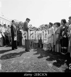 Besuch der internationalen Vertreter des Jr. Roten Kreuzes, 11:00am. Präsident John F. Kennedy (bei Mikrofonen) hält Bemerkungen an internationale Vertreter des Junior Red Cross auf dem West Wing Lawn. Präsident des amerikanischen Roten Kreuzes, General Alfred M. Grünther, steht links von Präsident Kennedy. White House, Washington, D.C. Stockfoto