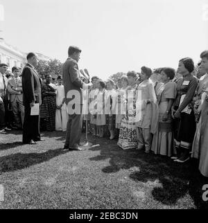 Besuch der internationalen Vertreter des Jr. Roten Kreuzes, 11:00am. Präsident John F. Kennedy (bei Mikrofonen) hält Bemerkungen an internationale Vertreter des Junior Red Cross auf dem West Wing Lawn. Präsident des amerikanischen Roten Kreuzes, General Alfred M. Grünther, steht links von Präsident Kennedy. White House, Washington, D.C. Stockfoto