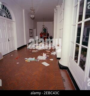 Geburtstagsfeier für Caroline Kennedy und John F. Kennedy, Jr.. Blick auf den Ostflügel-Korridor des Weißen Hauses, Washington, D.C., während einer gemeinsamen Geburtstagsfeier für Caroline Kennedy und John F. Kennedy, Jr.; Geschenke, Geschenkpapier und Schachteln bedecken den Boden. Im Hintergrund spielen Mitglieder der United States Marine Band, darunter der Akkordeonist Sergeant Major Charles Vincent Corrado. Stockfoto