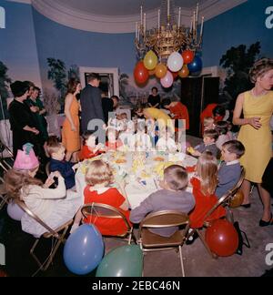 Geburtstagsfeier für Caroline Kennedy und John F. Kennedy, Jr.. Präsident John F. Kennedy und First Lady Jacqueline Kennedy (beide in der Mitte links) besuchen eine gemeinsame Geburtstagsfeier für ihre Kinder, Caroline Kennedy und John F. Kennedy, Jr.; Janet Auchincloss steht ganz links. Presidentu2019s Esszimmer (Residenz), White House, Washington, D.C. Stockfoto