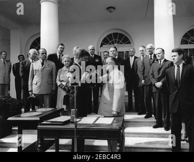 Übergabe der Distinguished Service Medal an General George H. Decker, 12:05pm Uhr. Präsident John F. Kennedy überreicht die Distinguished Service Medal (DSM) an den scheidenden Stabschef der US-Armee, General George H. Decker (Mitte). Im Blick auf (L-R): Militärhilfe an den Präsidenten, General Chester V. Clifton; Luftwaffenhilfe an den Präsidenten, Brigadier General Godfrey T. McHugh; Direktor der Central Intelligence Agency (CIA), John McCone; Vorsitzender der Joint Chiefs of Staff, General Lyman L. Lemnitzer; Vertreter George H. Mahon (Texas); Helen Decker; Stellvertretender Sekretär von De Stockfoto