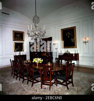 White House Zimmer: Family Dining Room. Tisch mit floralem Mittelpunkt im Family Dining Room im ersten Stock des Weißen Hauses, Washington, D.C., EIN Porträt von Präsident John Tyler, gemalt von George P. A. Healy im Jahr 1859, und zwei Stillleben-Gemälde (ganz links) des Künstlers Severin Roesen hängen an den Wänden; Der asiatische Lack-Faltschirm schmückt den Eingang zur Speisekammer auf der linken Seite. Stockfoto