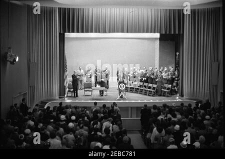 Europareise: Deutschland, Bonn: Ansprache im American Community Theatre vor dem amerikanischen Botschaftsstab, 2:45pm Uhr. Präsident John F. Kennedy (am Rednerpult) hält vor Mitarbeitern der amerikanischen Botschaft in Bad Godesberg, Bonn, Westdeutschland (Bundesrepublik) eine Rede. Beifall auf der Bühne, links von Präsident Kennedy (L-R): US-Staatssekretär, Dean Rusk; Militärhilfe an den Präsidenten, General Chester V. Clifton; Luftwaffenhilfe an den Präsidenten, Brigadier General Godfrey T. McHugh; Naval Aide an den Präsidenten, Captain Tazewell T. Shepard, Jr.; US-Botschafter in Westdeutschland, George C. McGhee (im Vordergrund Stockfoto