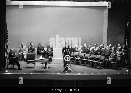 Europareise: Deutschland, Bonn: Ansprache im American Community Theatre vor dem amerikanischen Botschaftsstab, 2:45pm Uhr. Präsident John F. Kennedy (am Rednerpult) hält vor Mitarbeitern der amerikanischen Botschaft am Amerikanischen Theater Plittersdorf in Bad Godesberg, Bonn, Bundesrepublik Deutschland, eine Rede. Auf der Bühne sitzend, links von Präsident Kennedy (L-R): US-Staatssekretär, Dean Rusk; militärische Seite an den Präsidenten, General Chester V. Clifton; Air Force Aide an den Präsidenten, Brigadier General Godfrey T. McHugh; Naval Aide an den Präsidenten, Captain Tazewell T. Shepard, Jr.; US-Botschafter in West Stockfoto