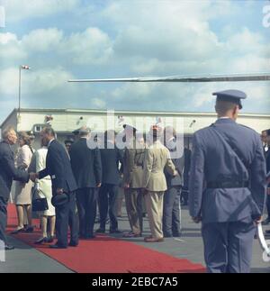 Europa-Reise: Deutschland, West-Berlin: Präsident Kennedy kommt am Flughafen Tegel an. Präsident John F. Kennedy (Mitte links, zurück zur Kamera) begrüßt die Beamten während seiner Ankunftszeremonie am Flughafen Tegel in West-Berlin (Bundesrepublik). Ebenfalls im Bild: Bundeskanzler von Westdeutschland, Konrad Adenauer; Eunice Kennedy Shriver; Militärhilfe an Präsident Kennedy, General Chester V. Clifton; US-Protokollchef, Angier Biddle Duke; US-Außenminister, Dean Rusk; französischer Kommandant in Berlin, Generalmajor Edouard Toulouse. Stockfoto