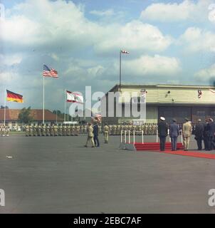 Europa-Reise: Deutschland, West-Berlin: Präsident Kennedy kommt am Flughafen Tegel an. Präsident John F. Kennedy (Mitte links, zurück zur Kamera) inspiziert Ehrengarden während seiner Ankunftszeremonie am Flughafen Tegel in West-Berlin (Bundesrepublik); französischer Kommandant in Berlin, Generalmajor Edouard Toulouse läuft links von Präsident Kennedy. Rechts stehen: Bundeskanzler Konrad Adenauer; Bürgermeister Willy Brandt; Naval Aide to the President, Captain Tazewell T. Shepard, Jr.; Air Force Aide to the President, Brigadier General Godfrey T. McHugh; Stockfoto