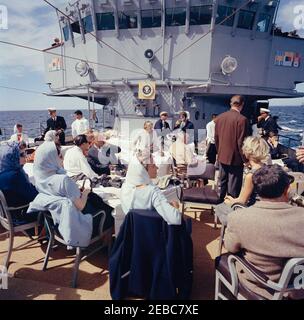 Präsident Kennedy beobachtet das 1st Americau0027s Cup Race. First Lady Jacqueline Kennedy (Mitte rechts, im Hintergrund) besucht mit dem Protokollführer Angier Biddle Duke an Bord der USS Joseph P. Kennedy, Jr., während des ersten Rennens des Cup 1962 Americau0027s. Im Vordergrund sitzen: Anita Fay; Sylvia Thomas Ormsby-Gore; Botschafter Großbritanniens, Sir David Ormsby-Gore; Botschafter der Vereinigten Staaten bei den Vereinten Nationen (UN), Adlai Stevenson; Janet Auchincloss; Unterstaatssekretär der Marine, Paul u0022Redu0022 Fay; Hugh D. Auchincloss. Auch abgebildet: Franklin D. Roosevelt, Jr.; Nav Stockfoto