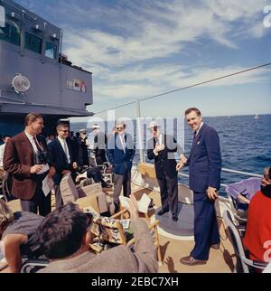 Präsident Kennedy beobachtet das 1st Americau0027s Cup Race. Präsident John F. Kennedy (mit Sonnenbrille) beobachtet das erste Rennen des Cup 1962 Americau0027s an Bord der USS Joseph P. Kennedy, Jr., vor der Küste von Newport, Rhode Island. Senator John O. Pastore (Rhode Island) und Senator Edmund S. Muskie (Maine) stehen rechts von Präsident Kennedy; Franklin D. Roosevelt, Jr., steht ganz links. Stockfoto
