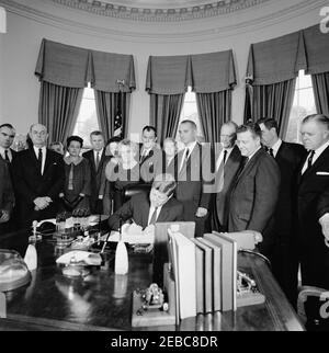 Unterzeichnungszeremonie, Senat Gemeinsame Resolution 133 Öffentliches Recht 87-702, Sam Rayburn Medaille, 12:20pm. Präsident John F. Kennedy (sitzt an der Rezeption) unterzeichnet eine gemeinsame Resolution des Senats, um eine Gedenkmedaille zu Ehren des verstorbenen Präsidenten des Repräsentantenhauses, Sam Rayburn (Texas), zu genehmigen. Stehend (L-R): Vertreter James C. Wright, Jr.; Vertreter Ray Roberts; ehemalige Mitarbeiter des verstorbenen House Speaker, Jack Neathery und Lorraine Kimbrough; Assistent des Sekretärs des Schatzamtes, Robert A. Wallace; ehemaliger Berater des verstorbenen House Speaker, Bernice Frazier; langjähriger Sekretär des verstorbenen House Sp Stockfoto