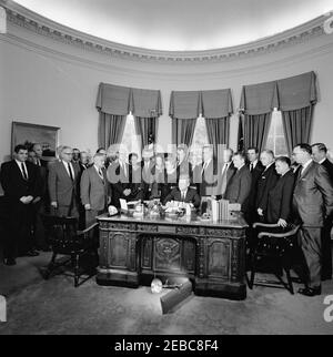 Unterzeichnungszeremonie, Senat Gemeinsame Resolution 133 Öffentliches Recht 87-702, Sam Rayburn Medaille, 12:20pm. Präsident John F. Kennedy (sitzt an der Rezeption) hält Bemerkungen nach der Unterzeichnung einer gemeinsamen Entschließung des Senats, um eine Gedenkmedaille zu Ehren des verstorbenen Präsidenten des Repräsentantenhauses, Sam Rayburn (Texas), zu genehmigen. Stehend (L-R): Vertreter Joe M. Kilgore; Assistent des Finanzsekretärs, Joseph W. Barr; Vertreter Graham Purcell; Vertreter John Dowdy; Vertreter Bob Casey (hinten, meist versteckt); Bundesgesetzgebenden Rat der American Bankers Association und ehemalige ADM Stockfoto