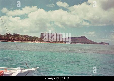 Reise nach Weststaaten: Honolulu, Hawaii, Besuch des USS Arizona Memorial, 2:40pm Uhr. Blick vom Meer von Waikiki Beach in Honolulu, Hawaii; das Waikiki Shore Apartmentgebäude steht im Zentrum. Rechts sind der Krater und der Gipfel des Diamond Head zu sehen. [Anmerkungen: Kratzer und Flecken im gesamten Bild sind Original zum Negativ.] Stockfoto