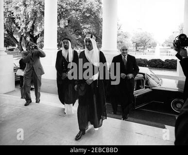 Mittagessen zu Ehren von Faisal ibn Abdul Aziz Al Saud, Kronprinz von Saudi-Arabien, 1:05pm Uhr. Kronprinz von Saudi-Arabien, Faisal ibn Abdul Aziz Al Saud, kommt im Weißen Haus zu einem Mittagessen zu seinen Ehren an. Von links nach rechts: Nicht identifizierter Filmfotograf (Gesicht von der Kamera verdeckt); Botschafter Saudi Arabiens, Scheich Abdullah Al-Khayyal; Kronprinz Faisal; US-Stellvertretender Protokollführer William J. Tonesk. North Portico, White House, Washington, D.C. Stockfoto