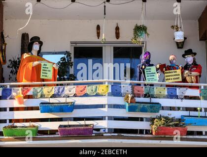 Sythen, Münsterland, NRW, 12th. Februar 2021. Eine Familie hat im kleinen Dorf Sythen bei Haltern-am-See in Nordrhein-Westfalen eine Szene mit gekleideten Shop-Dummies in Gesichtsmasken und positiven Ermutigungen zum "Bleiben optimistisch" auf ihrem Balkon inszeniert. Kredit: Imageplotter/Alamy Live Nachrichten Stockfoto